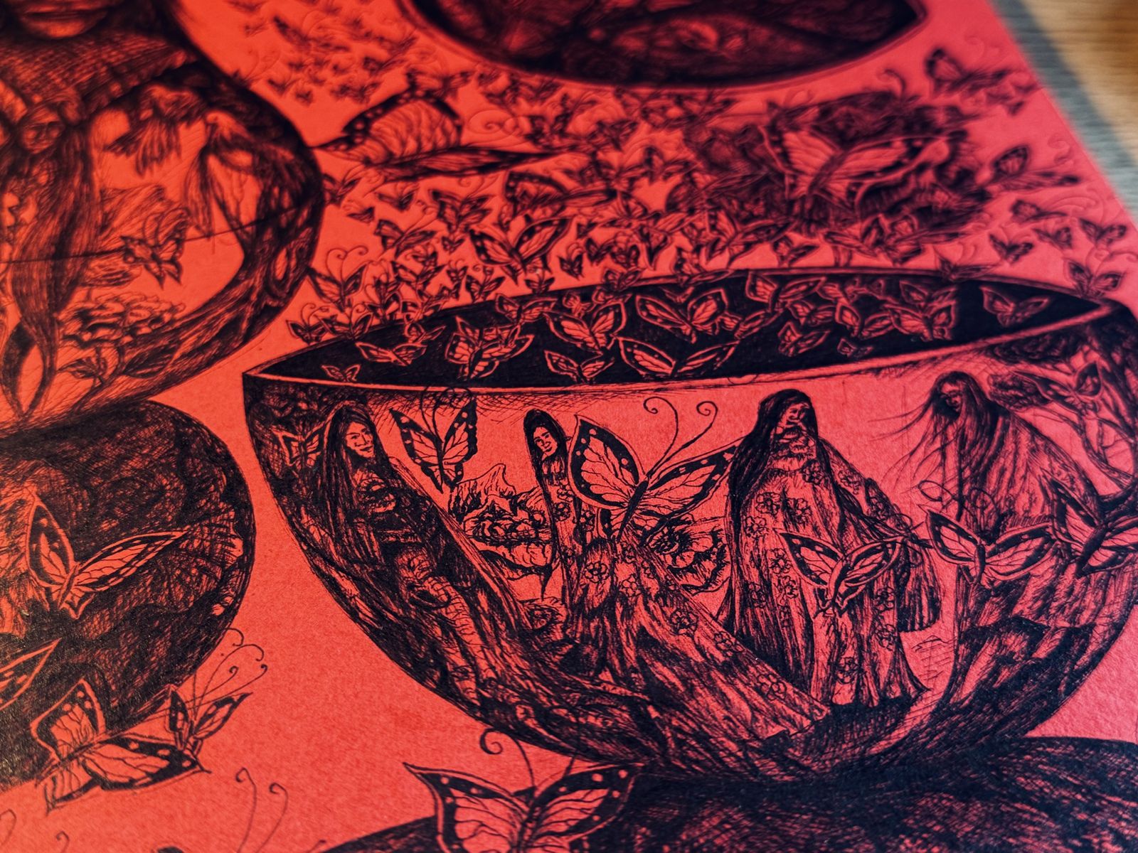 Detail: a bowl filled with long-haired figures and butterflies