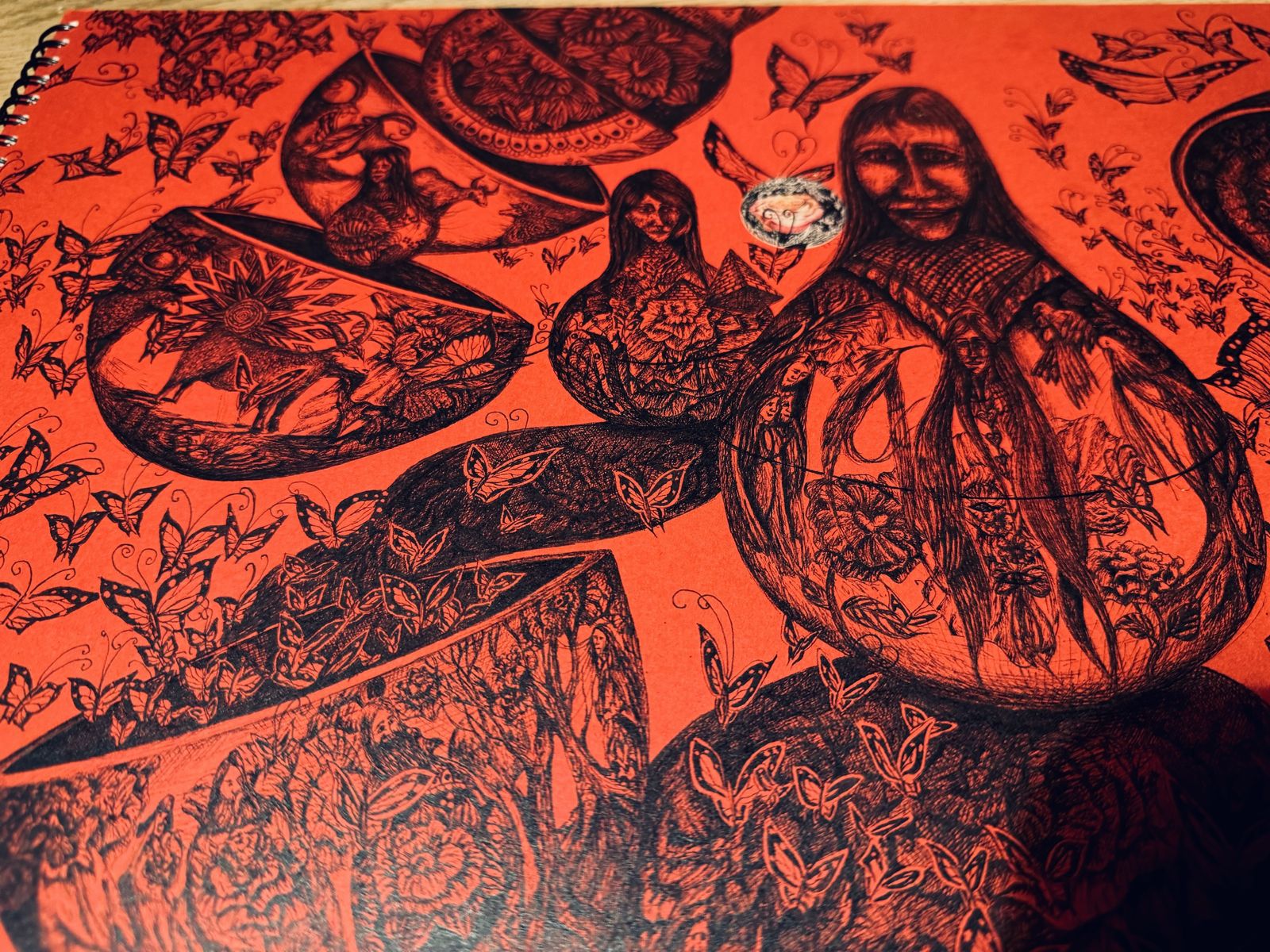 Dense black ink drawing on red paper of nesting vessels holding figures, flowers, animals and hundreds of butterflies