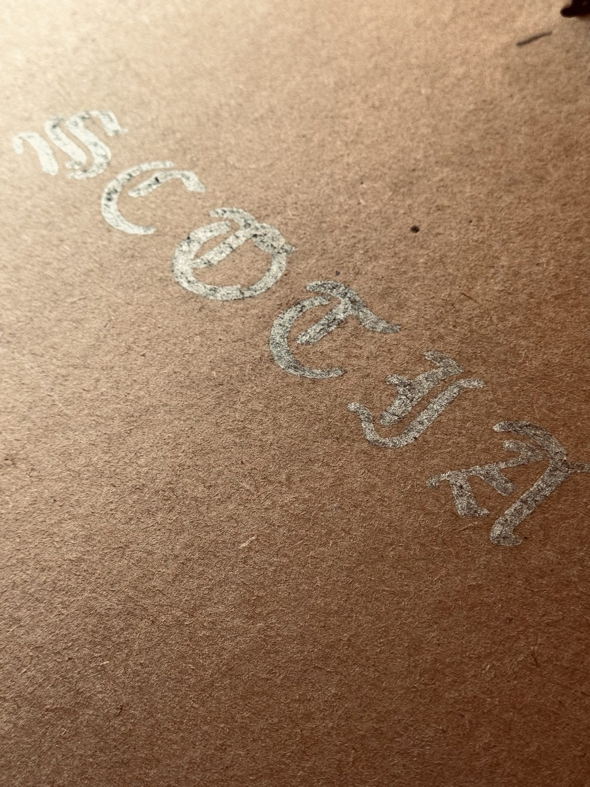 The title Scotia lettered in silver on brown kraft paper